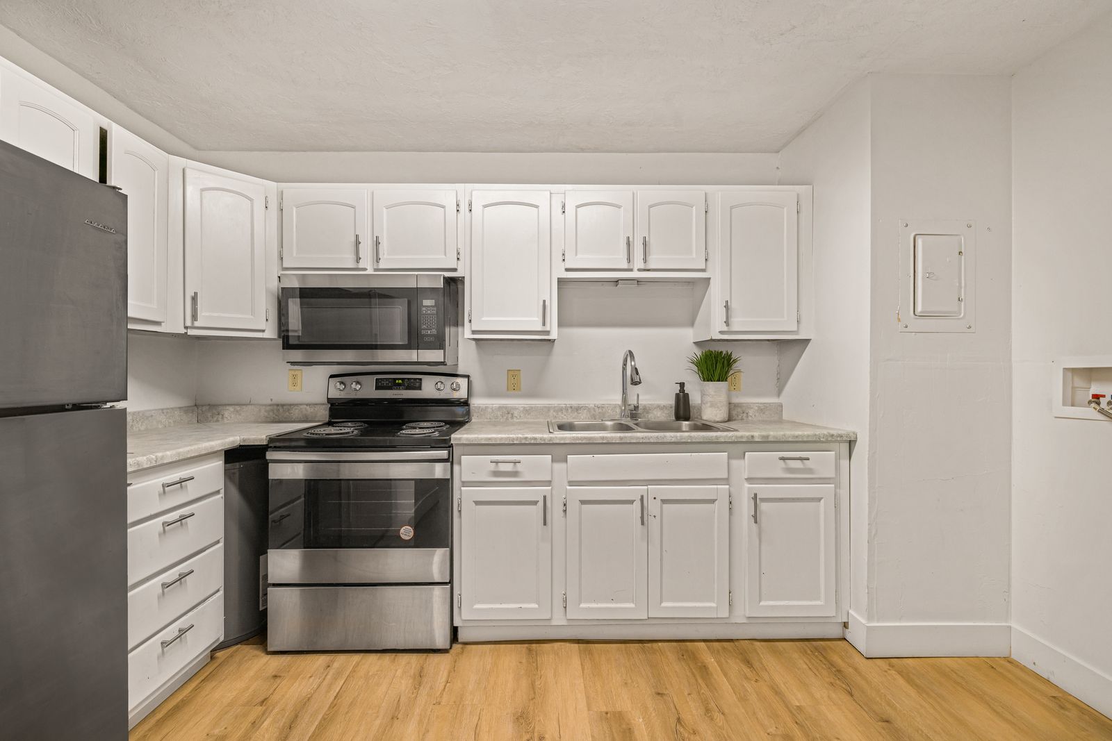 Renovated kitchen with white cabinetry and stainless appliances